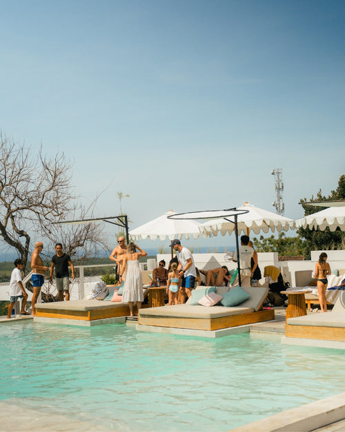 poolside Day Beds with people frolicking by the pool at Karana | Best Day Club in Nusa Lembongan